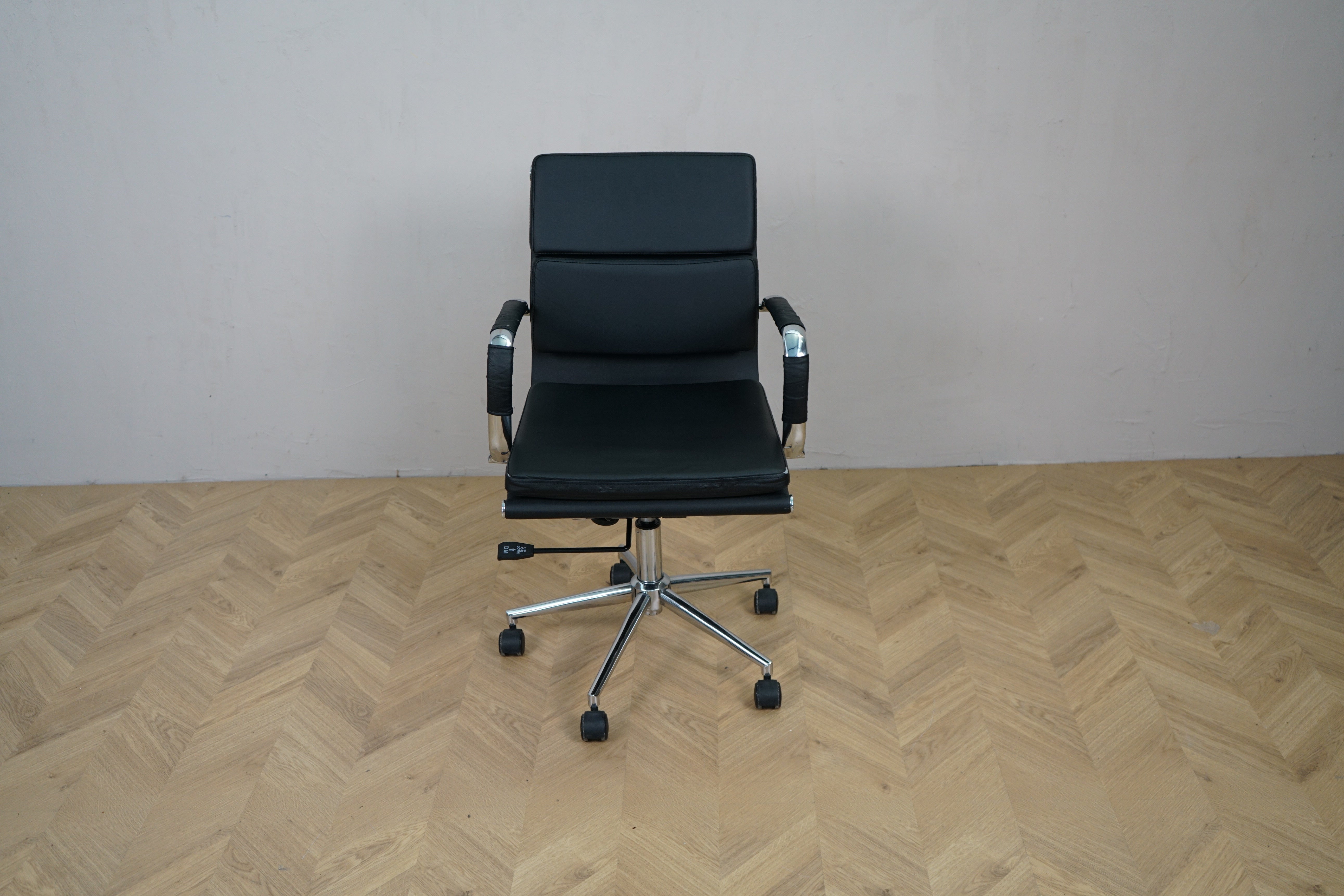 Konferencestol i sort læder med armlæn og krom fodkryds – frontvisning